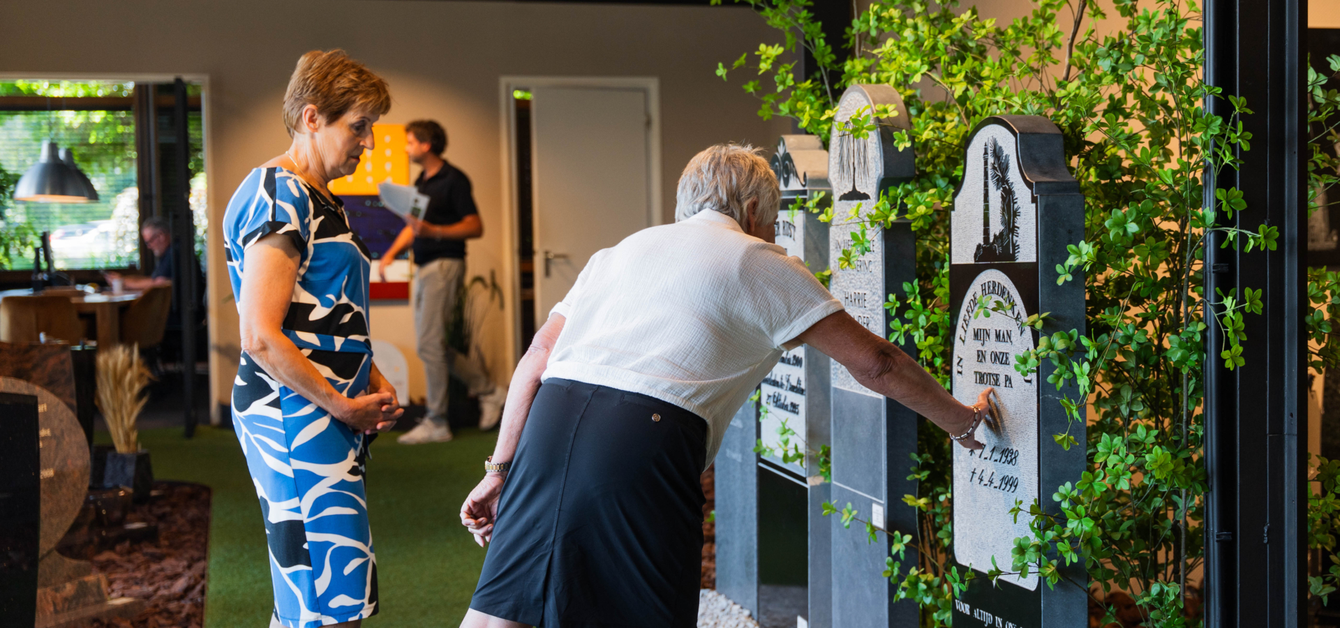 Bezoekers bekijken van dichtbij de grafmonumenten in de showroom