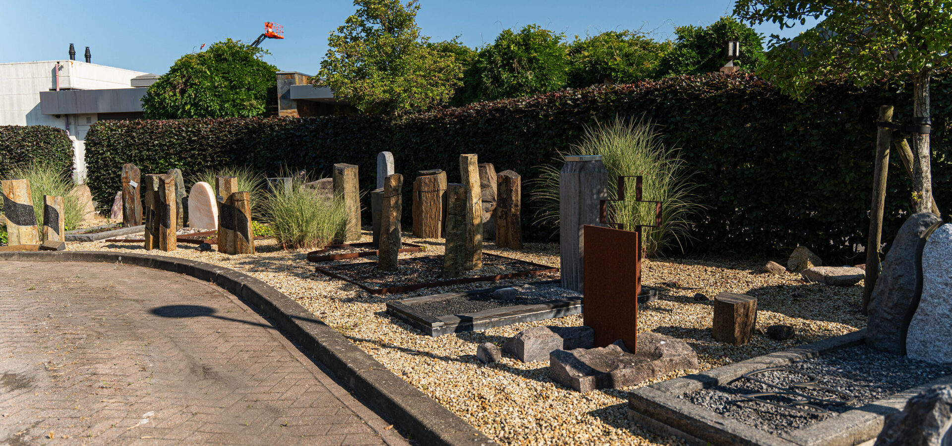 Overzicht van de buitenexpositie met grafmonumenten van natuursteen