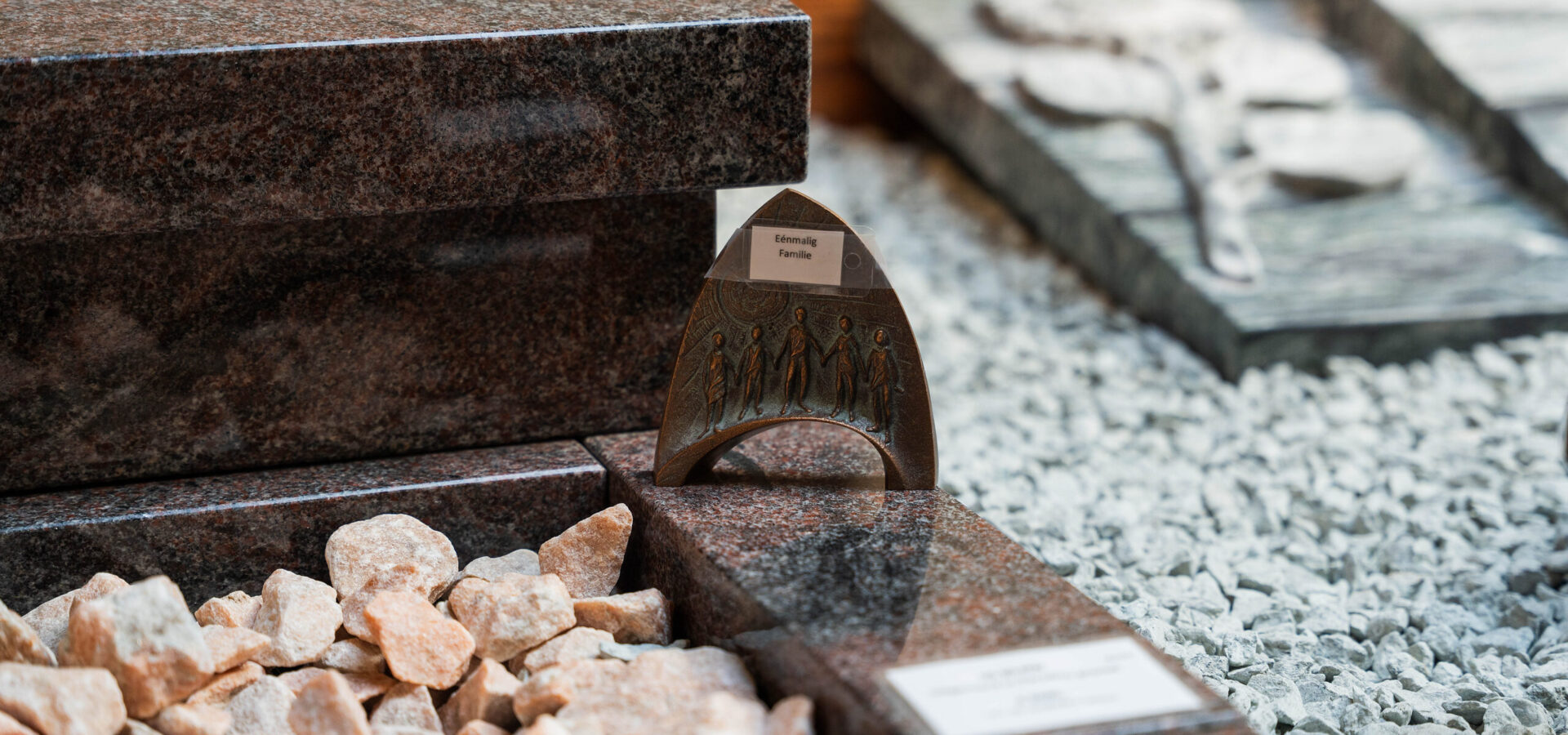 Detail van een grafsteen met grind en accessoires