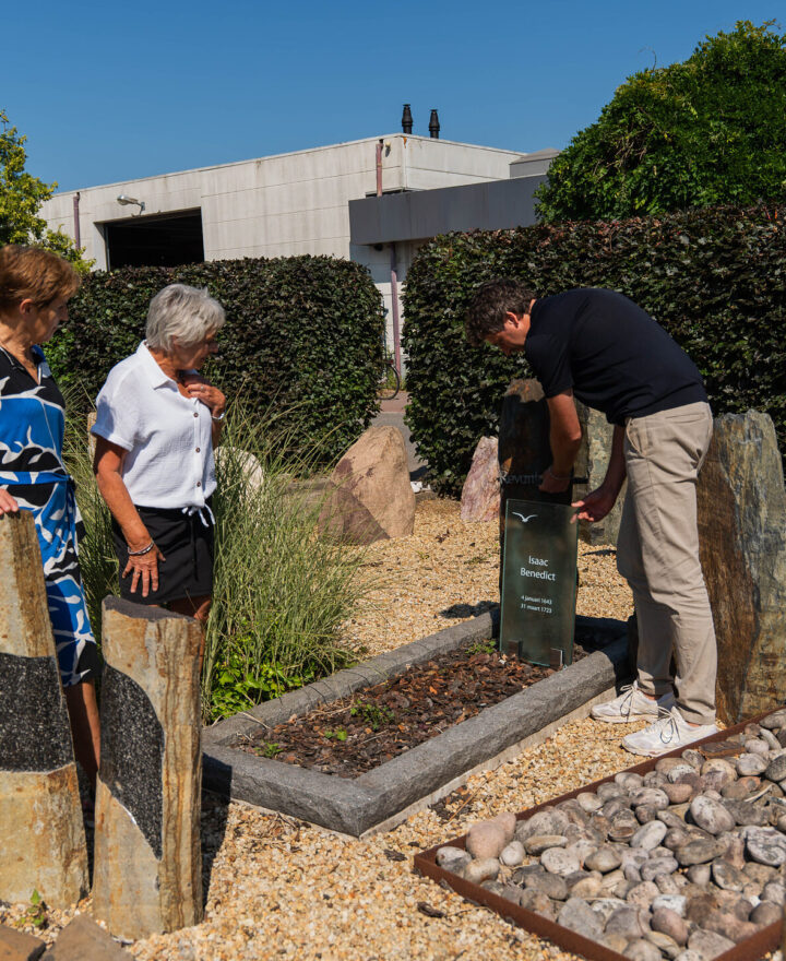 Klanten en adviseur bij de grafmonumenten in de buitenexpositie